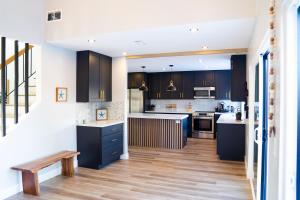 uma cozinha com armários pretos e piso em madeira em Island in the Hills Modern Poolside Home in San Diego em San Diego
