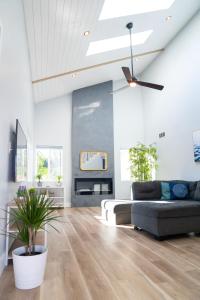 uma sala de estar com um sofá e uma ventoinha de tecto em Island in the Hills Modern Poolside Home in San Diego em San Diego