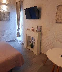 sypialnia z kominkiem i telewizorem na ścianie w obiekcie Bonito Alojamiento F w Walencji