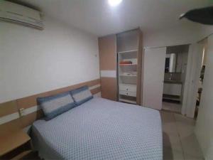 a bedroom with a bed with blue pillows at Apart Canoa Quebrada vista mar- condominio fechado in Aracati