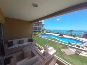 uma sala de estar com um sofá e vista para o oceano em Apart Canoa Quebrada vista mar- condominio fechado em Aracati
