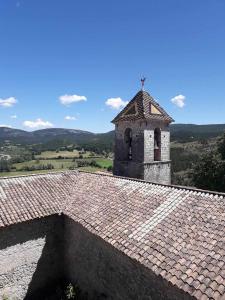 a building with a cross on top of a tile roof at Maison avec vue panoramique in Trigance