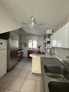 eine Küche mit Küchengeräten aus Edelstahl und einem Deckenventilator in der Unterkunft La Torretta in Marina di Lizzano
