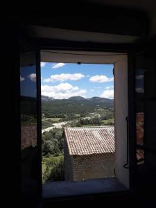 a window in a building looking out at the countryside at Maison avec vue panoramique in Trigance