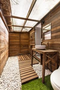 baño con lavabo y pared de madera en Bali Cozy Bungalows, Nusa Dua Benoa, en Nusa Dua