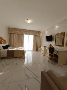 a hotel room with two beds and a desk at HOTEL PARADISE in Porto Cesareo