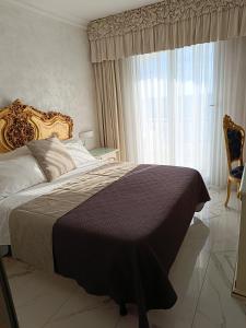 a bedroom with a bed and a large window at HOTEL PARADISE in Porto Cesareo