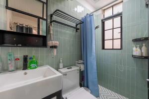 a bathroom with a white sink and a toilet at Shanghai Century Old House Downtown B&B in Shanghai