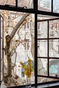 una finestra con un vaso con fiori gialli di Shanghai Century Old House Downtown B&B a Shanghai