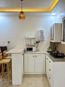eine Küche mit weißen Schränken und einer Mikrowelle in der Unterkunft Vihaa - a boutique stay in Velha Goa