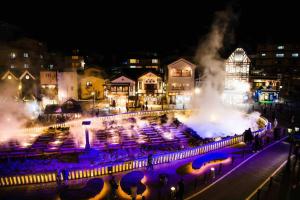 a city at night with a fountain in the middle at 源泉掛け流し付き貸切別荘-Authentic private home with Private Kusatsu Onsen - THE HIDEOUT VILLA KUSATSU- in Kusatsu
