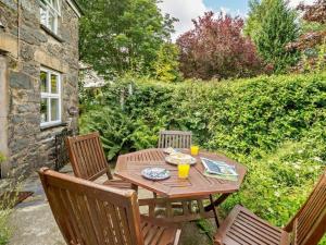 a wooden table with two chairs and a tableasteryasteryasteryasteryasteryasteryastery at 1 Penygroes in Penmachno