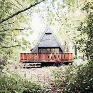 een kleine hut met een terras in het bos bij Chalet 228 in Durbuy