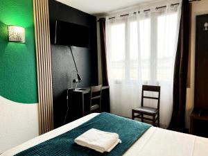 a bedroom with a bed with a green wall at Brit Hotel Confort Gien in Gien