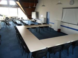 a class room with tables and chairs and a whiteboard at Brit Hotel Confort Gien in Gien