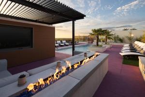 un patio al aire libre con chimenea y piscina en AC Hotel by Marriott Gainesville Downtown en Gainesville