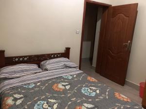 Schlafzimmer mit einem Bett und einem Holzschrank in der Unterkunft Luxury Furnished and Serviced Home in Kigali