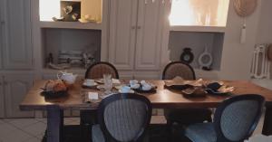 een eettafel met stoelen en een tafel met hoeden erop bij La maison perchee in Aigues-Mortes