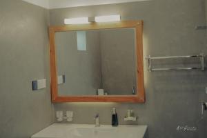ein Badezimmer mit einem Spiegel und einem Waschbecken in der Unterkunft HotelNuvin AHANGAMA in Ahangama