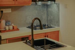 a kitchen sink with a faucet next to a stove at HotelNuvin AHANGAMA in Ahangama