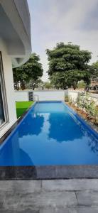 una gran piscina azul junto a una casa en Joshi Villa, en Talāsri
