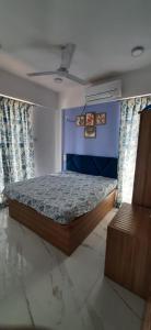 1 dormitorio con cama y pared azul en Joshi Villa, en Talāsri