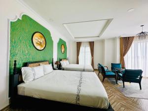 sypialnia z 2 łóżkami i zieloną ścianą w obiekcie Khách Sạn The One Hotel 1 w mieście Cà Mau