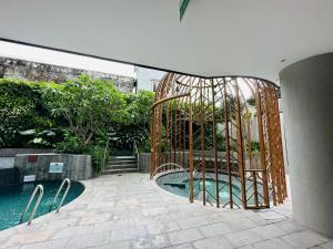 una jaula de metal junto a una piscina en D1 Mension Luxury Apartment- Chloe Dang, en Ho Chi Minh