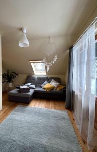 a living room with a black couch and a chandelier at River House in Nītaure