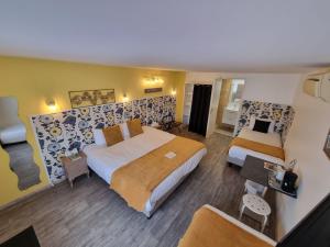 ein Hotelzimmer mit 2 Betten und einem Sofa in der Unterkunft Cit'Hotel Les Atlantes in Médis