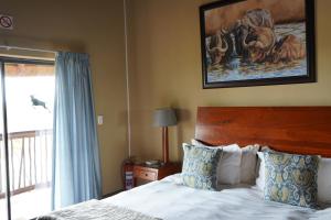 a bedroom with a bed and a painting on the wall at Lucca Lodge in Musina