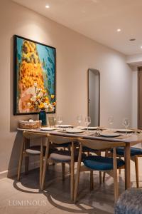 uma sala de jantar com uma grande pintura na parede em D1 Mension Luxury Apartment- Chloe Dang em Ho Chi Minh
