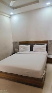 a bed with white sheets and pillows in a room at hotelbhavya in Ahmedabad