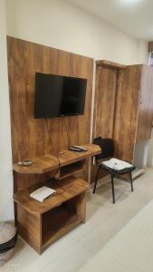 a living room with a tv and a wooden wall at hotelbhavya in Ahmedabad