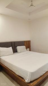 a large bed with white sheets and pillows at hotelbhavya in Ahmedabad