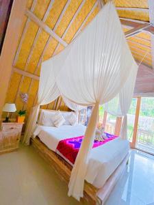 een slaapkamer met een hemelbed bij Batur cottage in Kubupenlokan