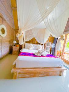 a bedroom with a large bed with a canopy at Batur cottage in Kubupenlokan