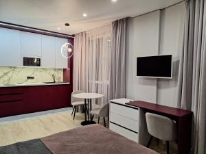 Pokój hotelowy z łóżkiem, biurkiem i telewizorem w obiekcie Сучасні апартаменти в новобудові w Lwowie