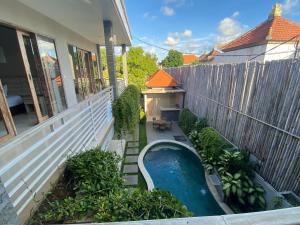 a swimming pool on the side of a house at Rusty Seminyak in Seminyak