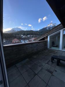 a balcony with a bench and a view of mountains at Geräumiges sonniges Apartment mit Bergblick in Imst