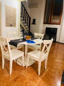 una mesa de comedor blanca y sillas con copas de vino en San felice studio en Bolonia