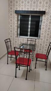 un tavolo con due sedie e un tavolo e due finestre di Goroomgo Blue Bell Bhubaneswar a Bhubaneshwar