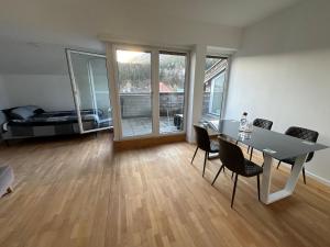 a living room with a table and chairs and a bed at Geräumiges sonniges Apartment mit Bergblick in Imst