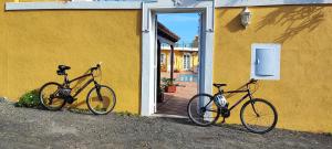 duas bicicletas estacionadas ao lado de um edifício amarelo em Volcán de Sal em Mazo