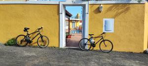 twee fietsen geparkeerd naast een geel gebouw bij Espuma de Sal in Mazo