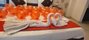 two white swans with balloons on a bed at Goroomgo Blue Bell Bhubaneswar in Bhubaneshwar