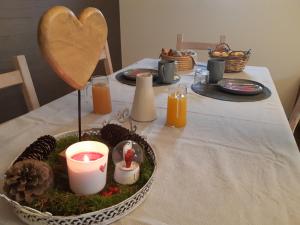 un tavolo con un piatto di cibo e candele sopra di B&B Caprice d'Epices a Francorchamps