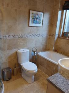 a bathroom with a toilet and a tub and a sink at Ceol Na Mara (Music of the Sea) in Rosemarkie