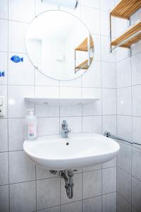 a white bathroom with a sink and a mirror at Ferienwohnungen Saida Wohnung 3 in Norden