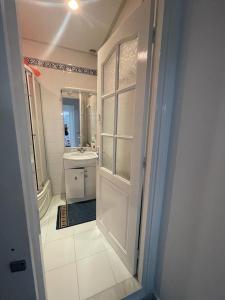 a bathroom with a white door and a sink at APPART SARAH Plage in Hammamet Nord +15 photos